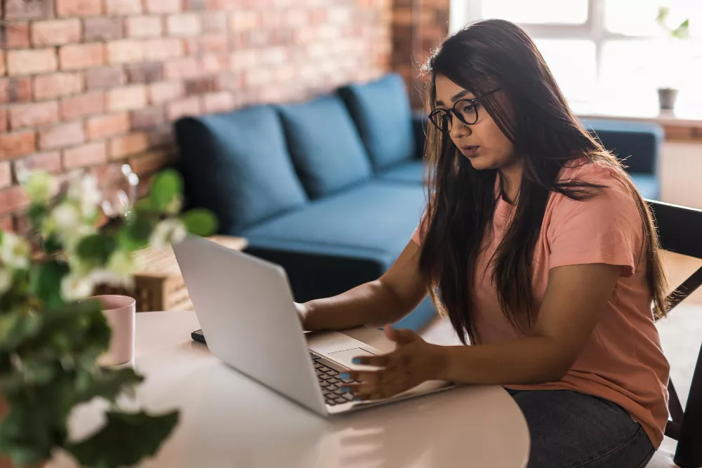 Femme utilisant son ordinateur portable dans le salon