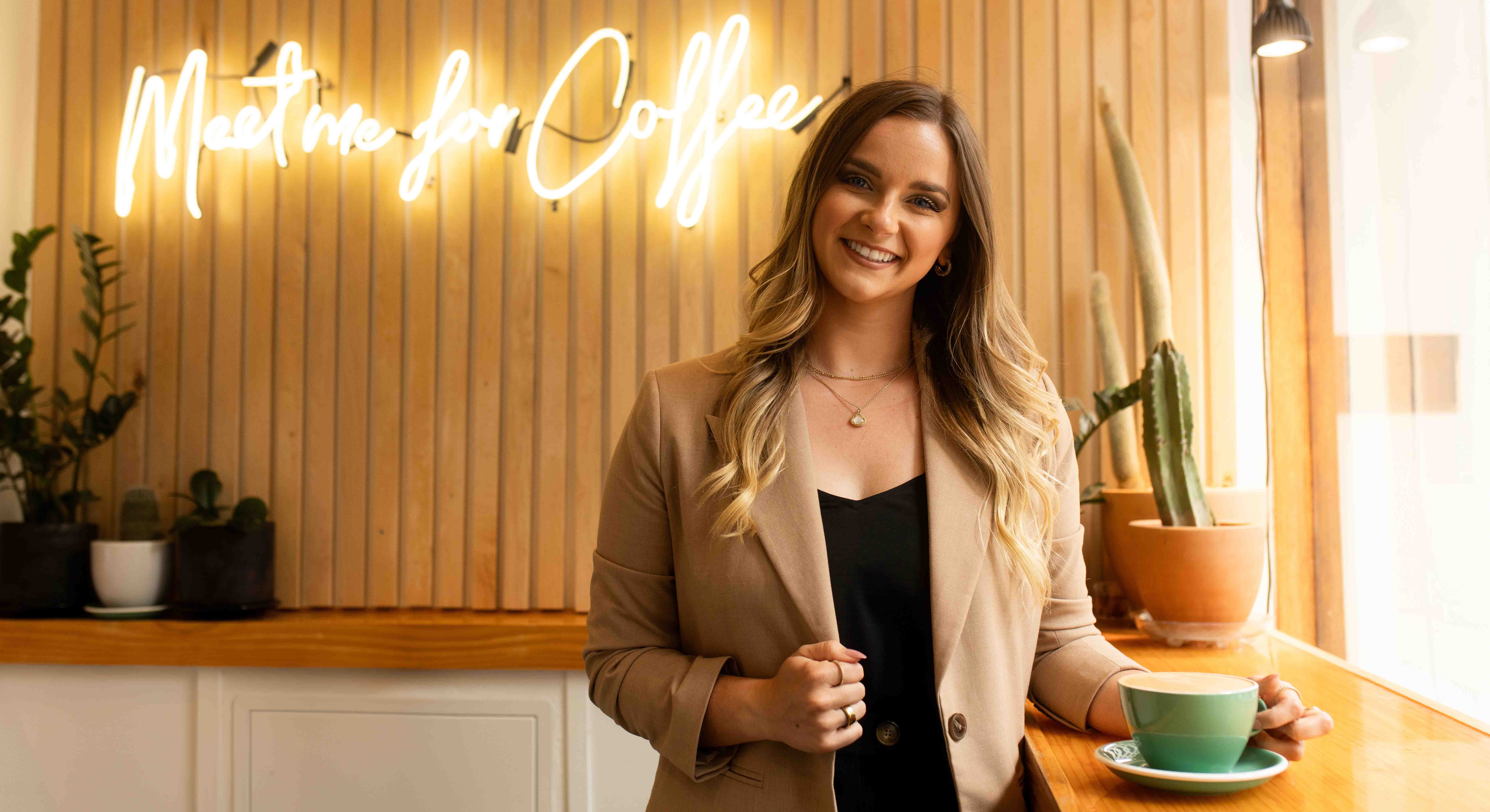 Samantha Jones standing at a table with a coffee mug