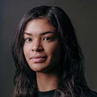 Portrait of a woman with long dark hair against a dark background.