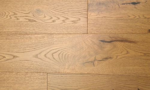 Modernes Schlafzimmer mit Holzfliesenboden, Bett mit gestreifter Bettwäsche und großer Glasfront zur Terrasse.