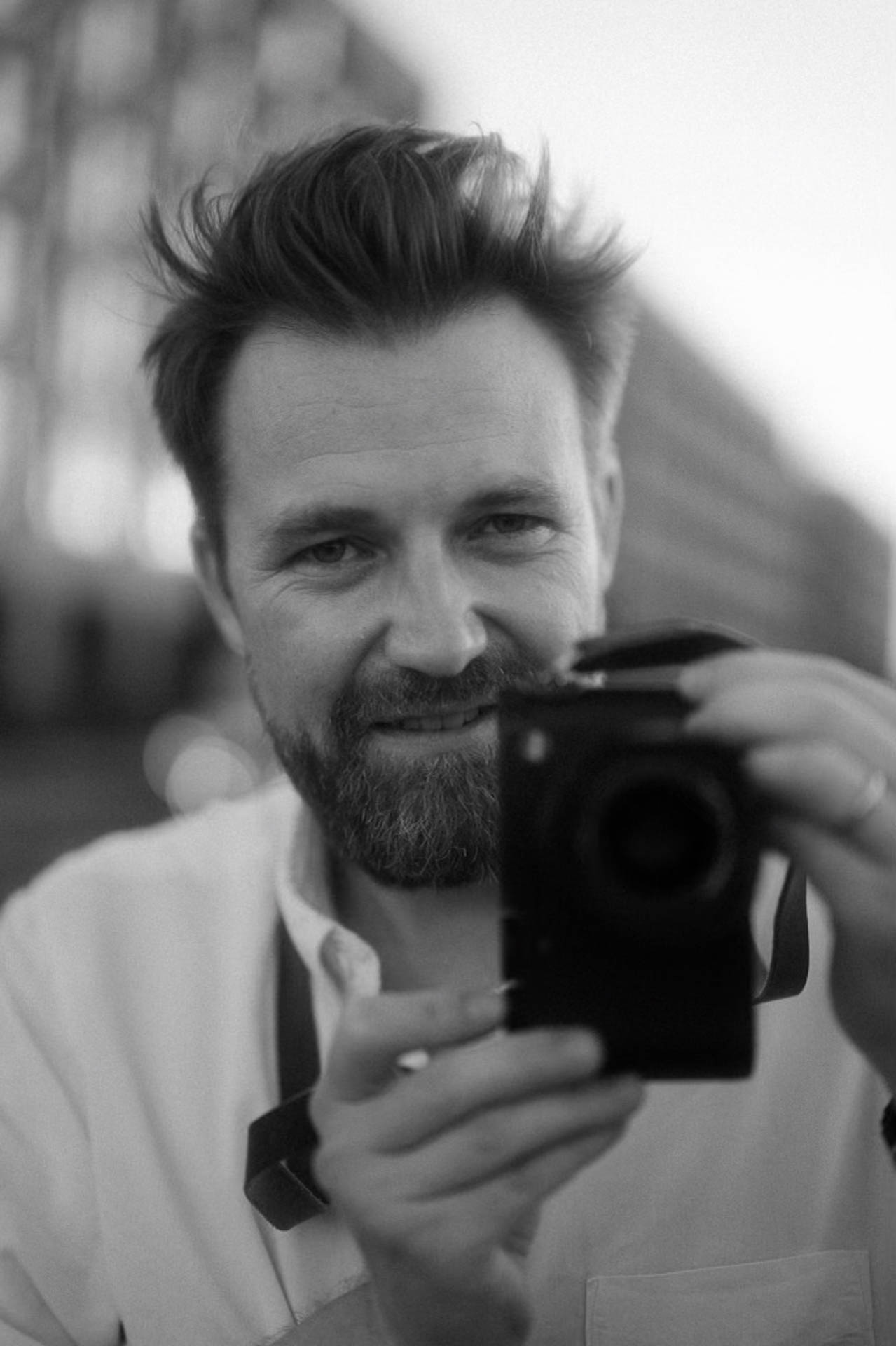 A young photographer, Chris Kaeppel from Nuremberg wearing a Leica Q3
