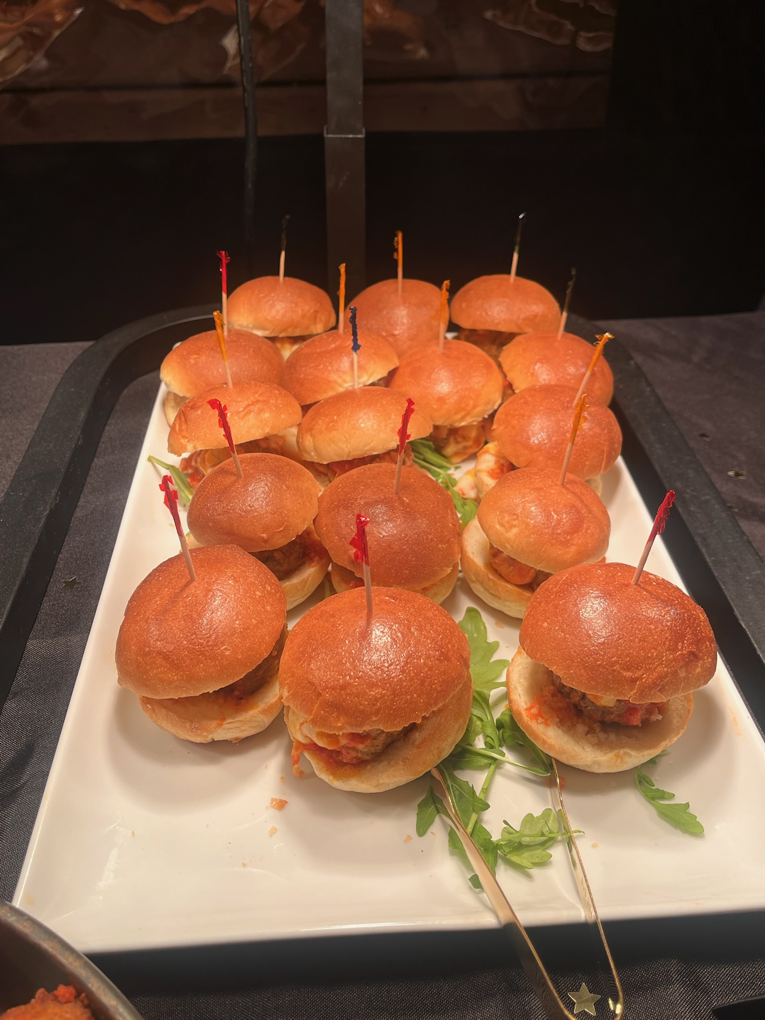 Buffalo wings platter with ranch and blue cheese dressings available in pump bottles at a sports-themed catering setup.
