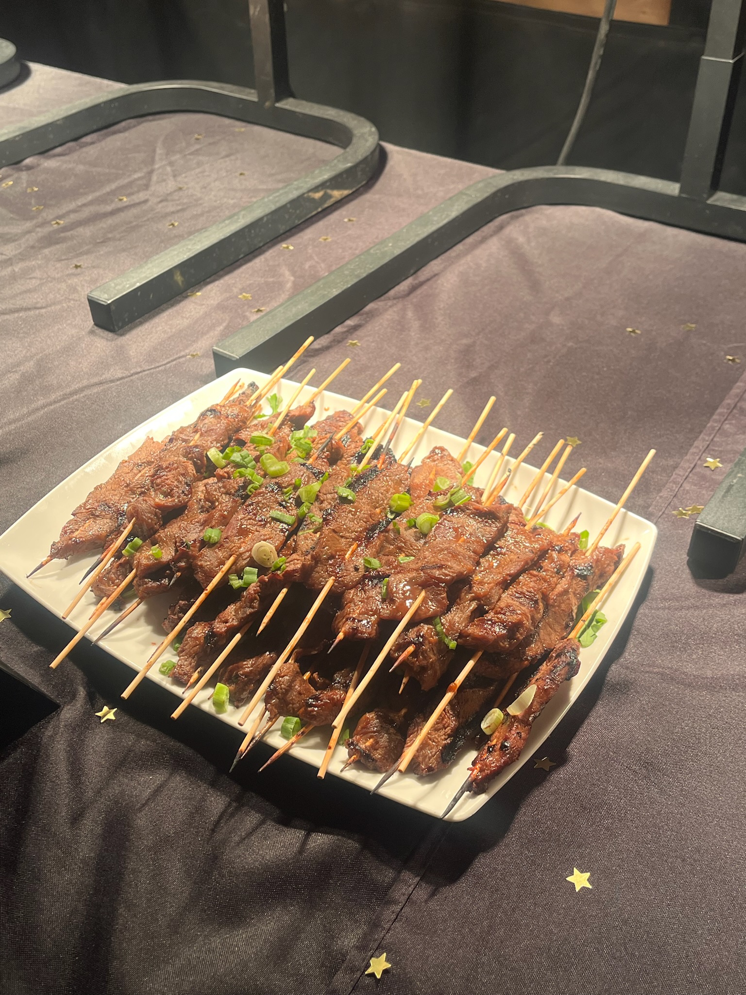 Elegant buffet table featuring soups served from a large pump container, surrounded by fresh bread and toppings.
