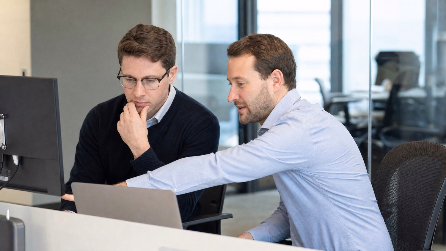 SIDE-BY-SIDE PAIR An IT professional two people seated side by side reviewin