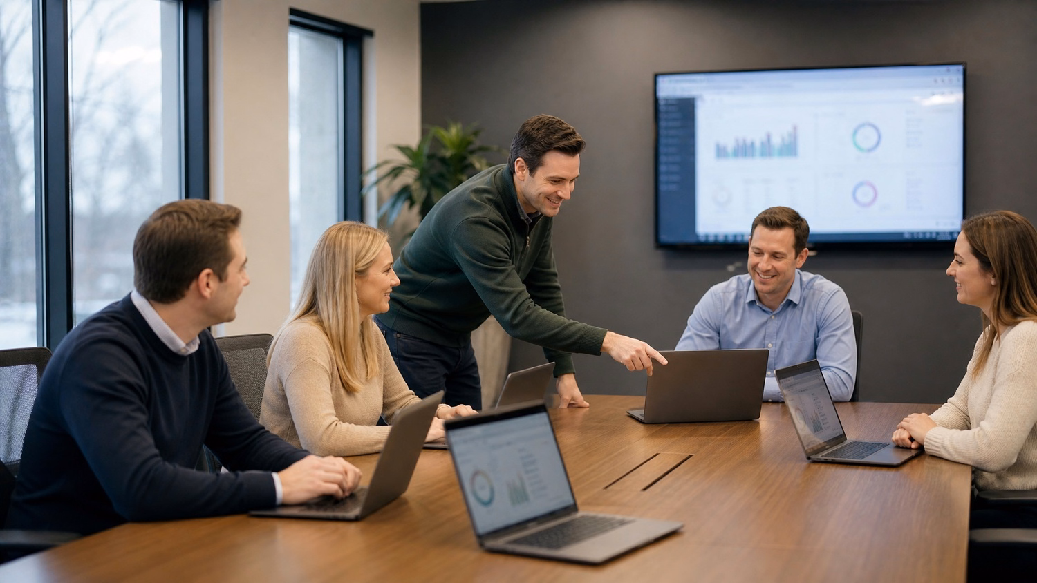 Boardroom team reviewing charts, one pointing at screen 67