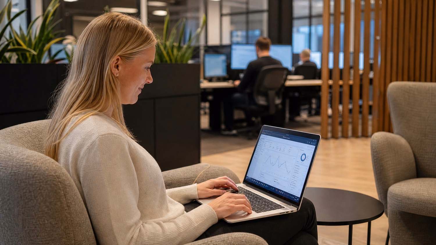 Woman at lounge laptop reviewing call volume dashboard