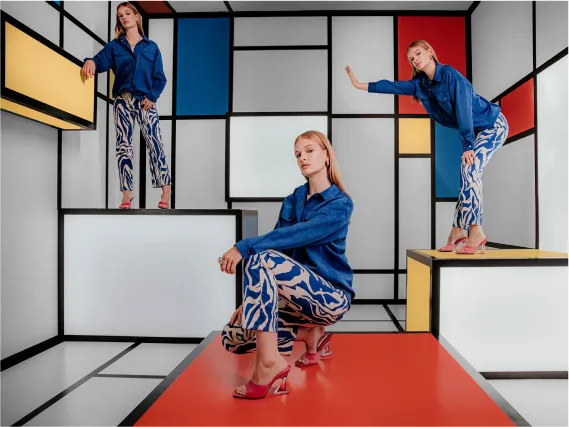 A woman in a blue shirt and patterned pants.