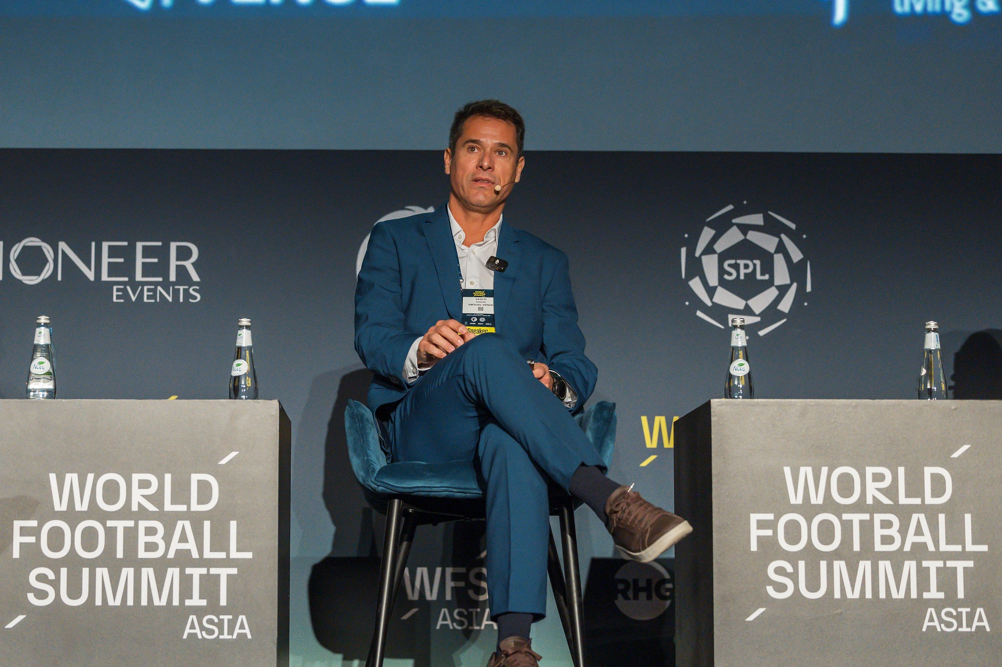 Vasco Pinheiro, Managing Partner, onstage at World Football Summit Asia in Riyadh, speaking on “The Stadium Experience” panel with several sports logos on the backdrop.