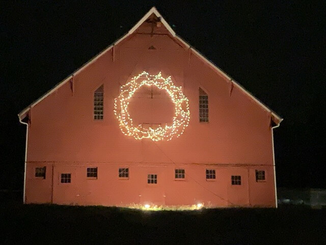 Kristoferson Farm barn  decorated with a lit holiday wreath