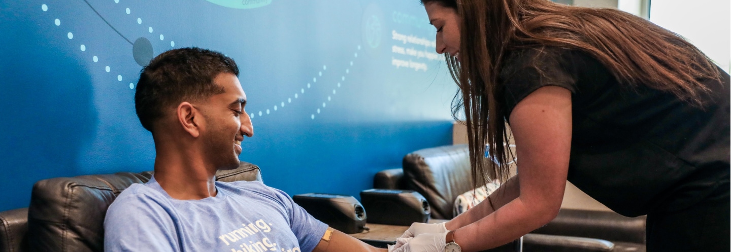Smiling patient receiving iv therapy from smiling Restore employee.