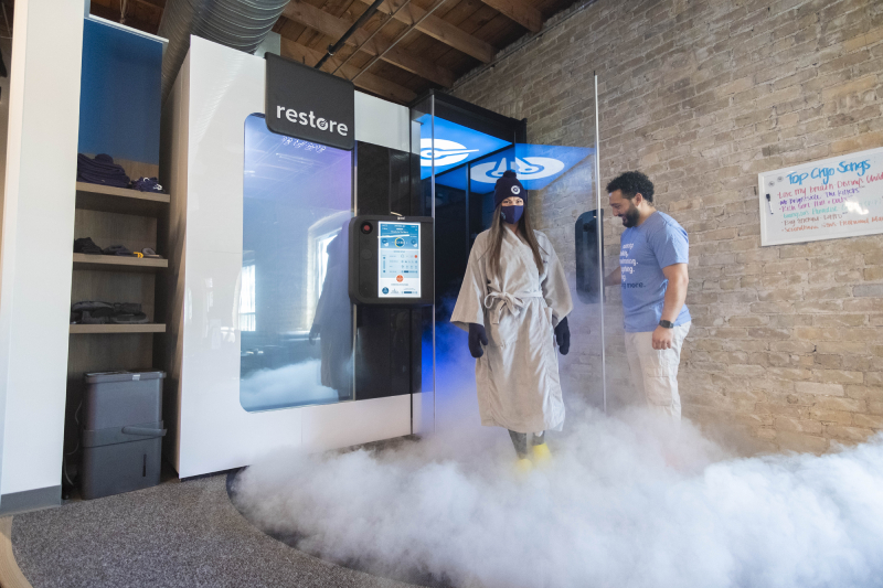 Man and woman smiling at each other while getting Normatec compression treatment. 