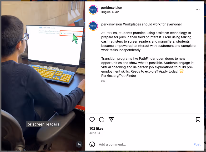 A student wearing glasses uses a desktop computer with a yellow-on-black high-contrast keyboard and screen. A large cursor points to a section of the screen that reads “Desk Phone.” On-screen captions read “or screen readers.” The Instagram caption describes how students at Perkins use assistive technology, including screen readers and magnifiers, to prepare for employment.