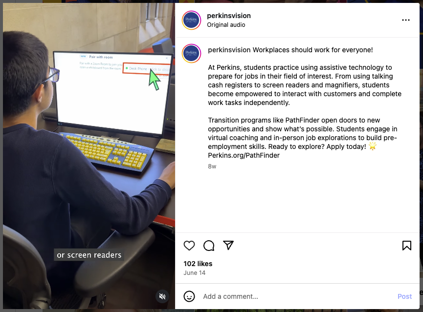 A student wearing glasses uses a desktop computer with a yellow-on-black high-contrast keyboard and screen. A large cursor points to a section of the screen that reads “Desk Phone.” On-screen captions read “or screen readers.” The Instagram caption describes how students at Perkins use assistive technology, including screen readers and magnifiers, to prepare for employment.