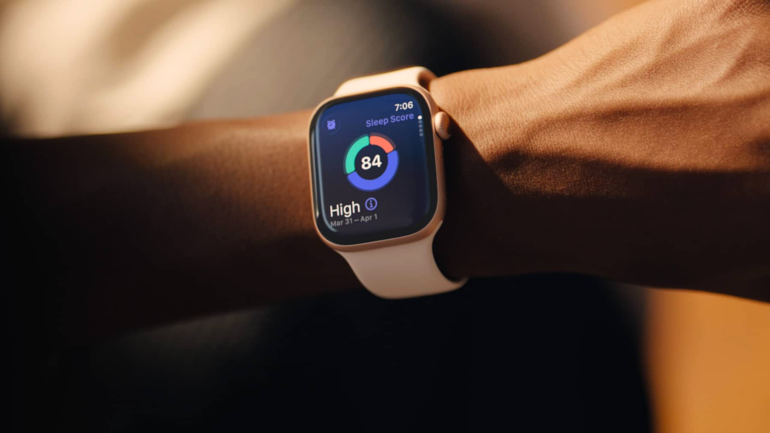 Close-up of an Apple Watch on a person’s wrist showing a sleep score of 84 and the time 7:06.