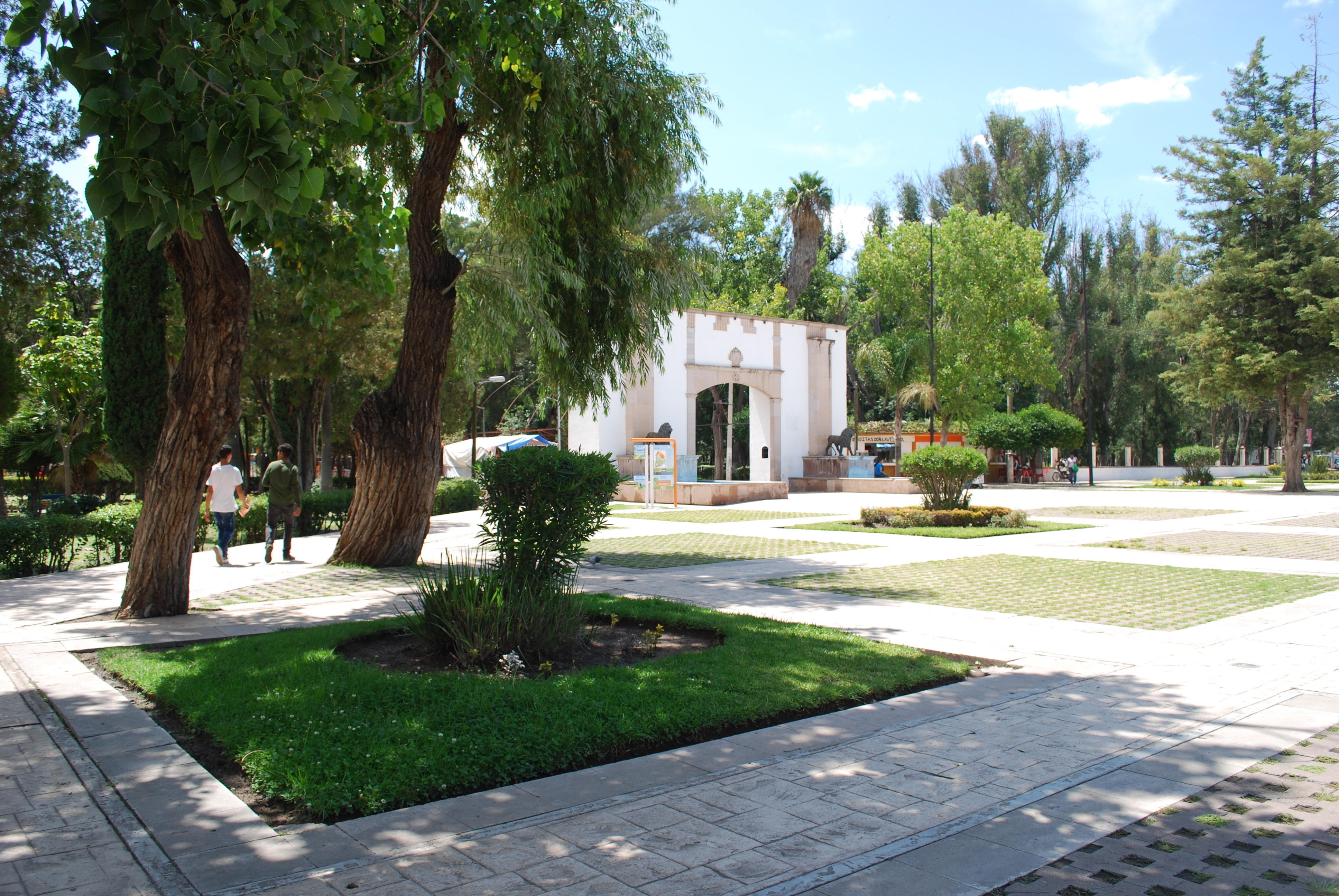 Andadores arbolados y acceso monumental del Parque Guadiana en Durango.