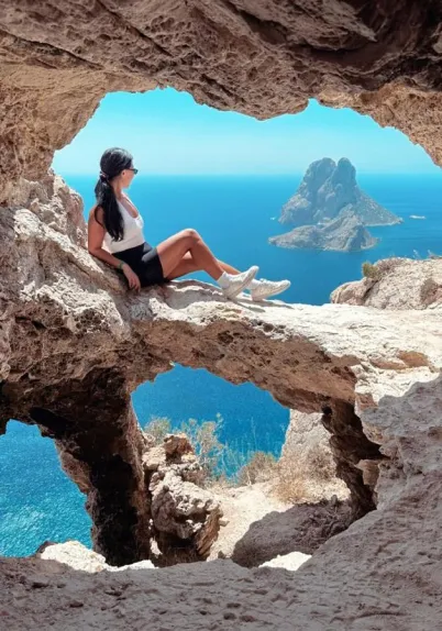 Person in cave by sea.