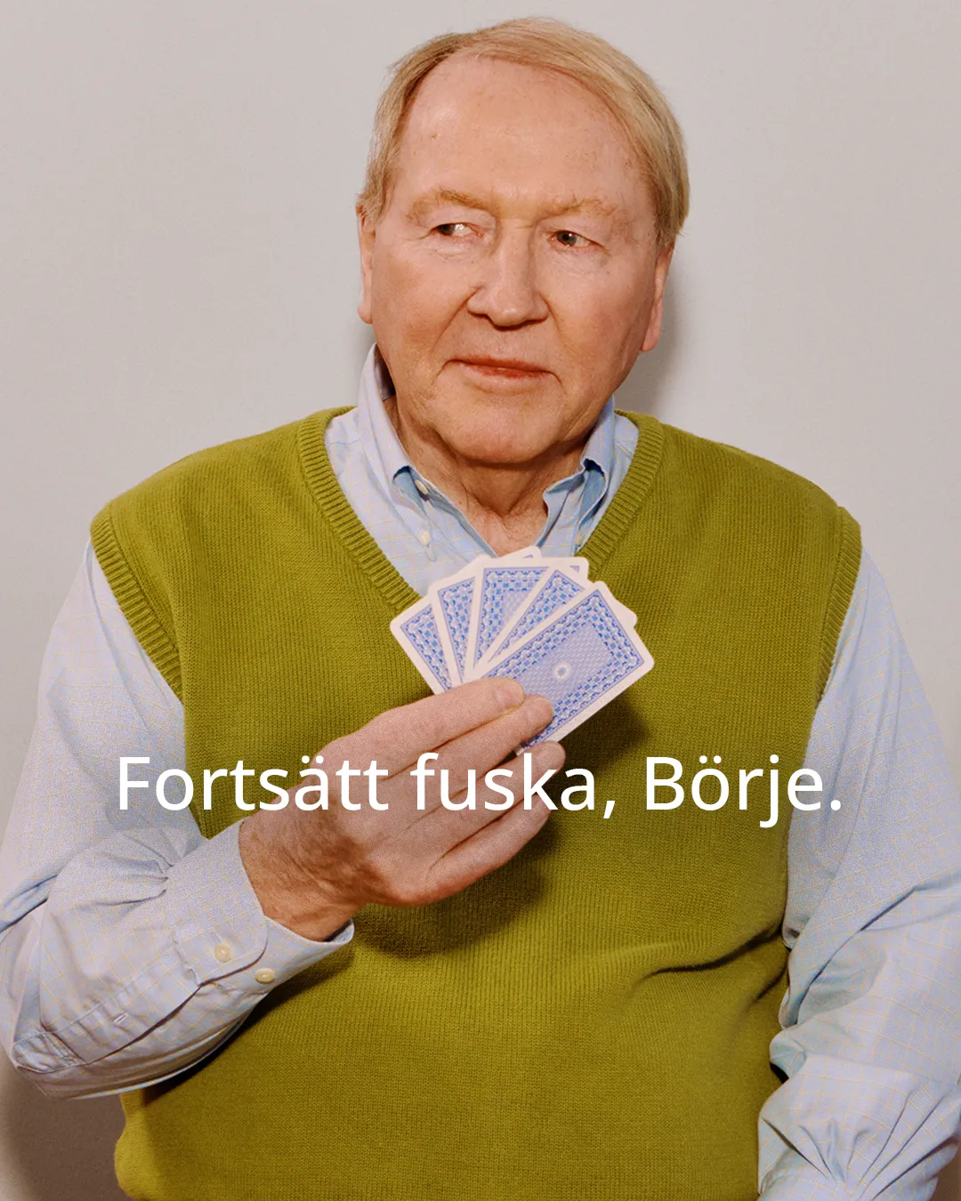 Foto på äldre man som håller i spelkort