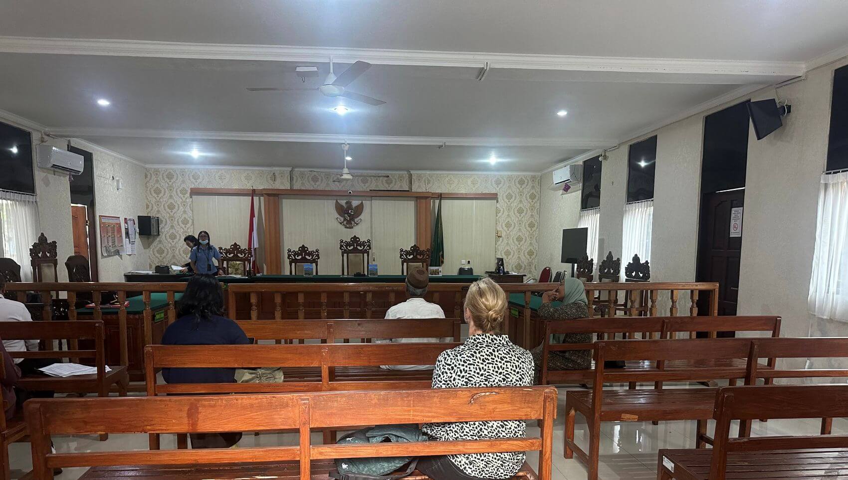 People sitting inside a court room in Bali