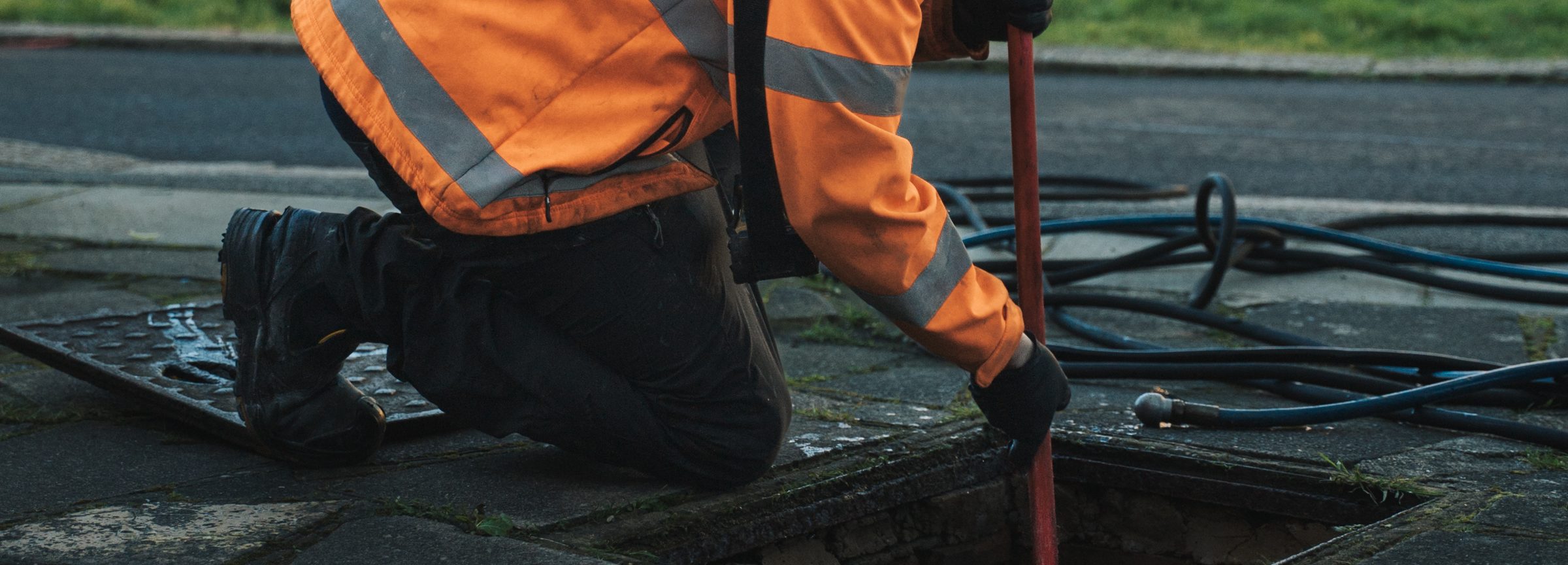 FS Group engineer rodding a blocked drain through an open manhole