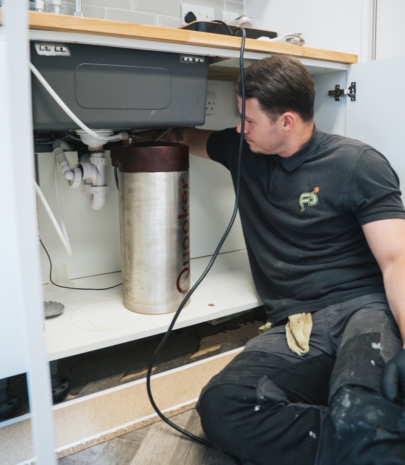 FS Group engineer checking the waste pipe under a sink