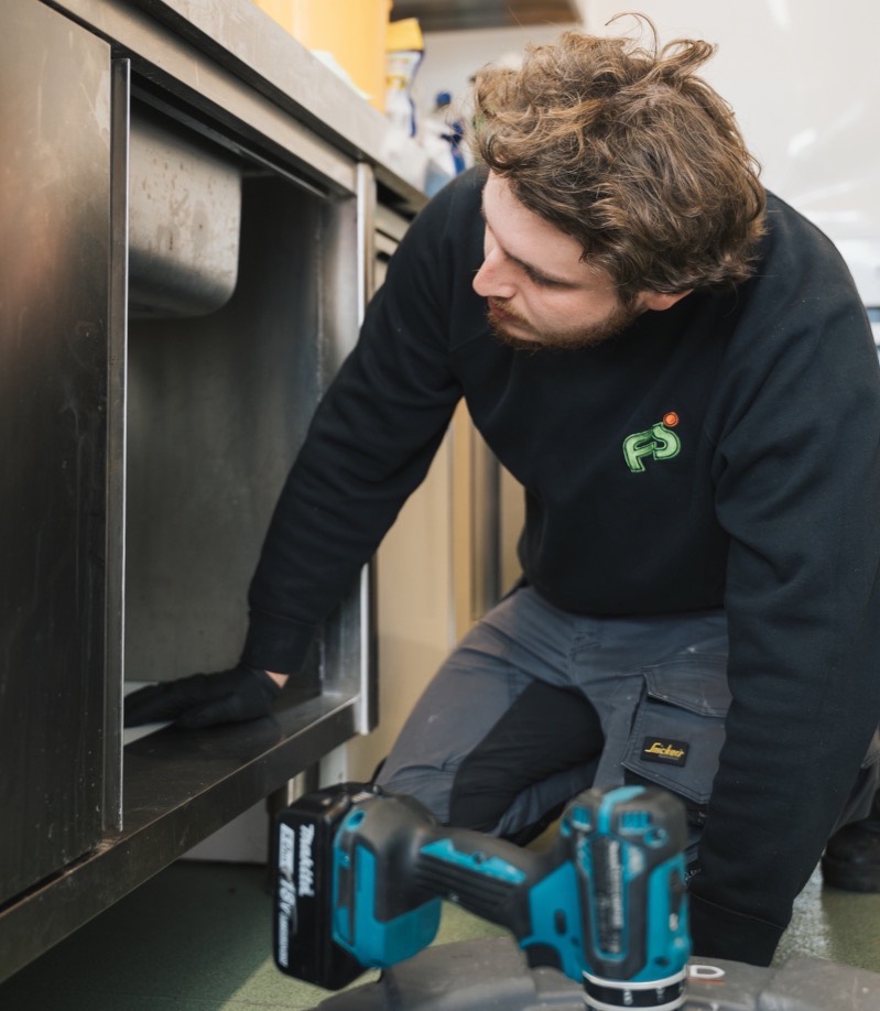 FS Group engineer clearing a drain in a commercial kitchen