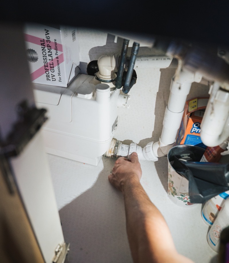 FS Group engineer checking pipework joints inside a cupboard