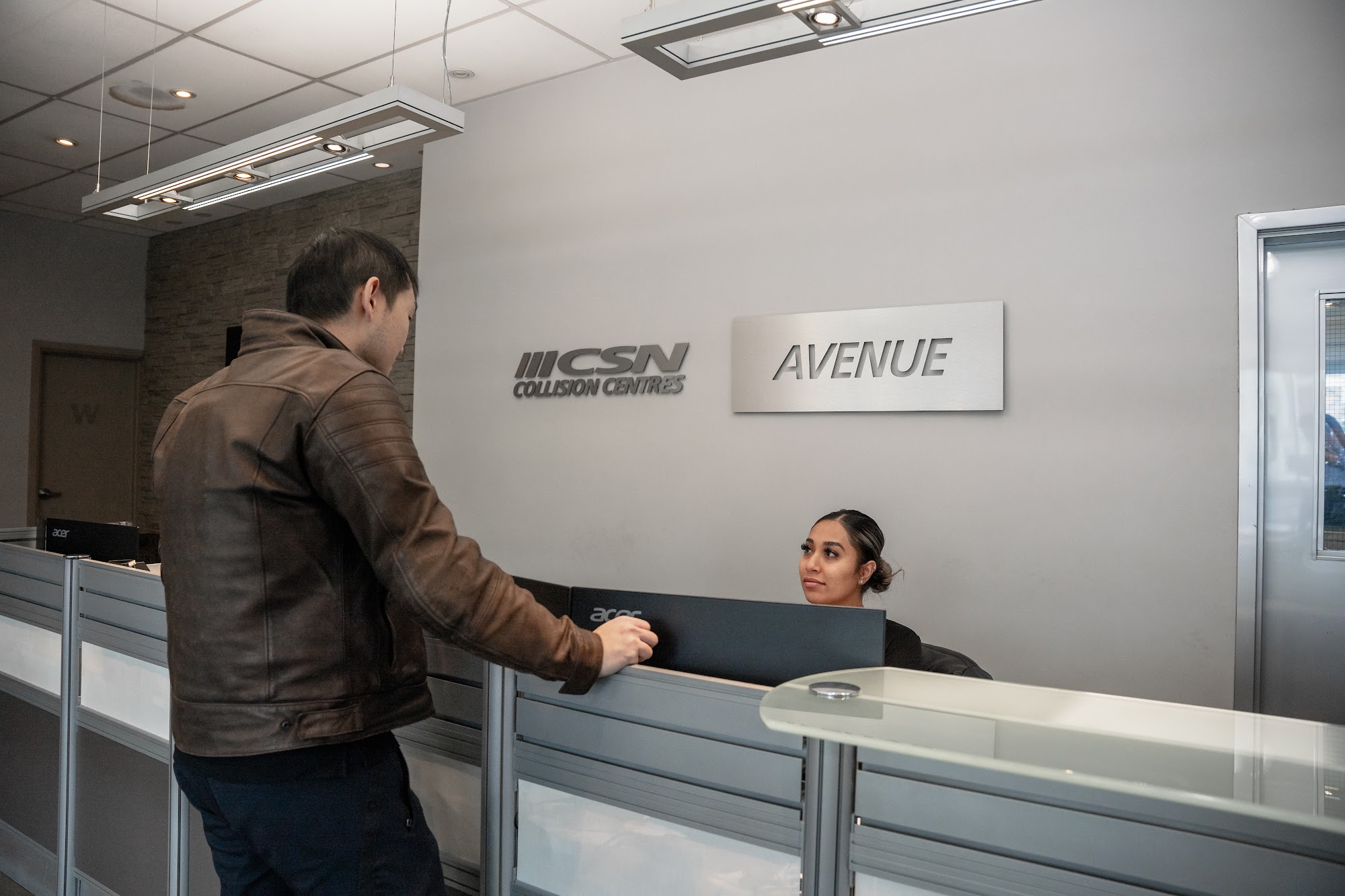 A customer checking in at the CSN Avenue Collision reception desk in downtown Toronto