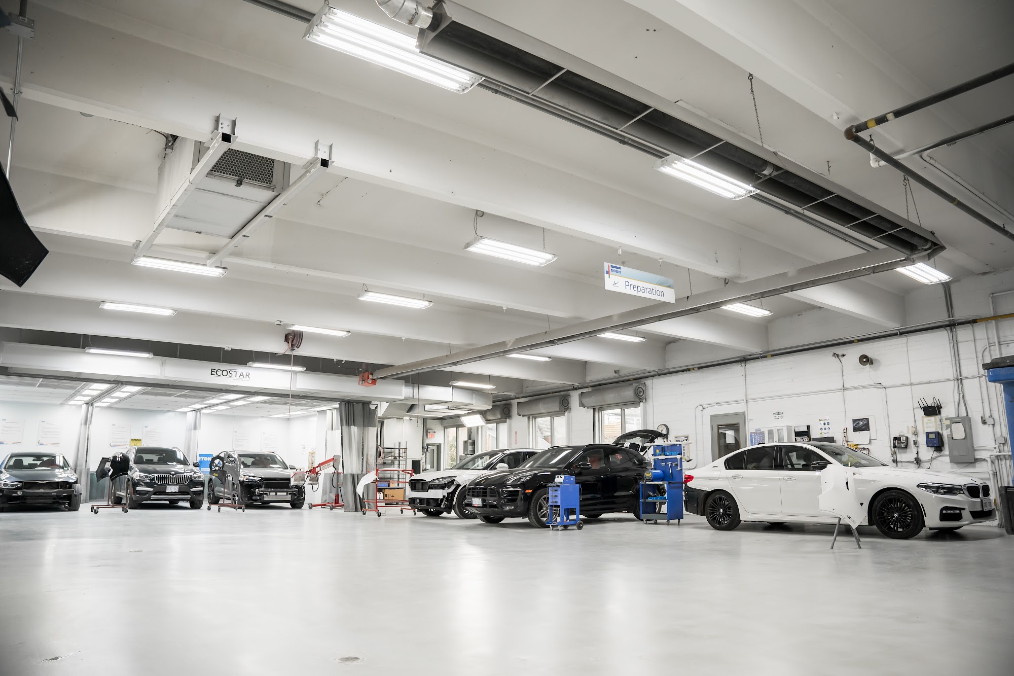 A black Porsche Macan undergoing repair on the shop floor at CSN Avenue Collision in Toronto