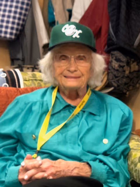 An older woman wearing a green shirt and a green hat