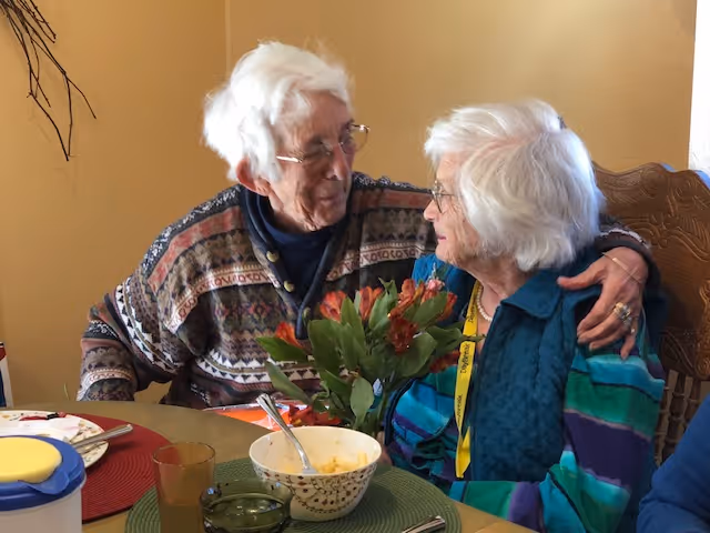 A couple of older people sitting at a table