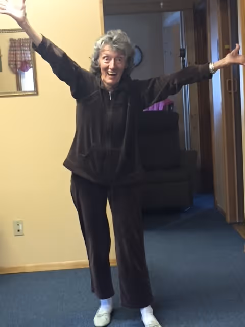 A woman standing in a room with her arms in the air