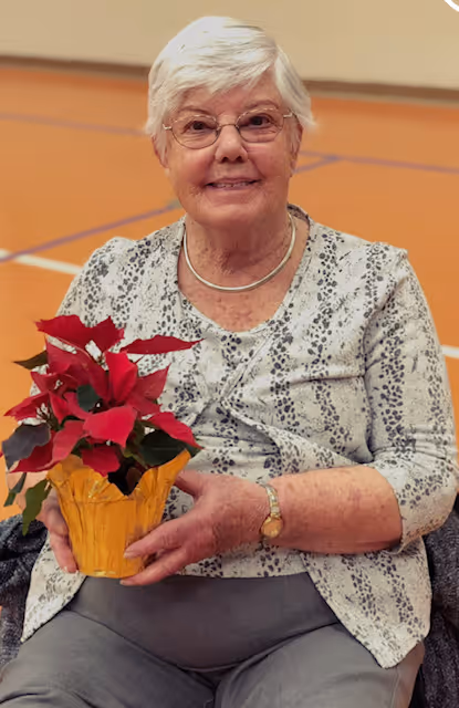 A woman sitting in a chair holding a potted plant