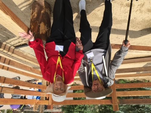 Two people upside down on a wooden platform