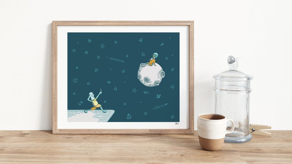 Mockup of the "Cooper the Astronaut" illustration in a light wood frame sitting on a counter next to a decorative coffee mug and cookie jar. The illustration inside the frame is illustration drawn in a whimsical, cartoonish style showing a dog in astronaut gear appear disproportionately on top of a moon. Instead of stars surrounding the cosmic body, there are tiny spot illustrations of various items of clothing, hats, dog bones, underwear, etcetera. In the foreground, a cartoon character is holding up a pencil almost like a magical wand pointed at the dog.