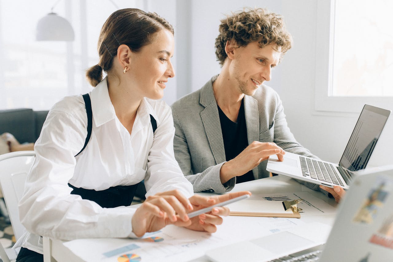 Woman in White Long Sleeve Button Up Shirt Sitting beside Man in Gray Blazer
