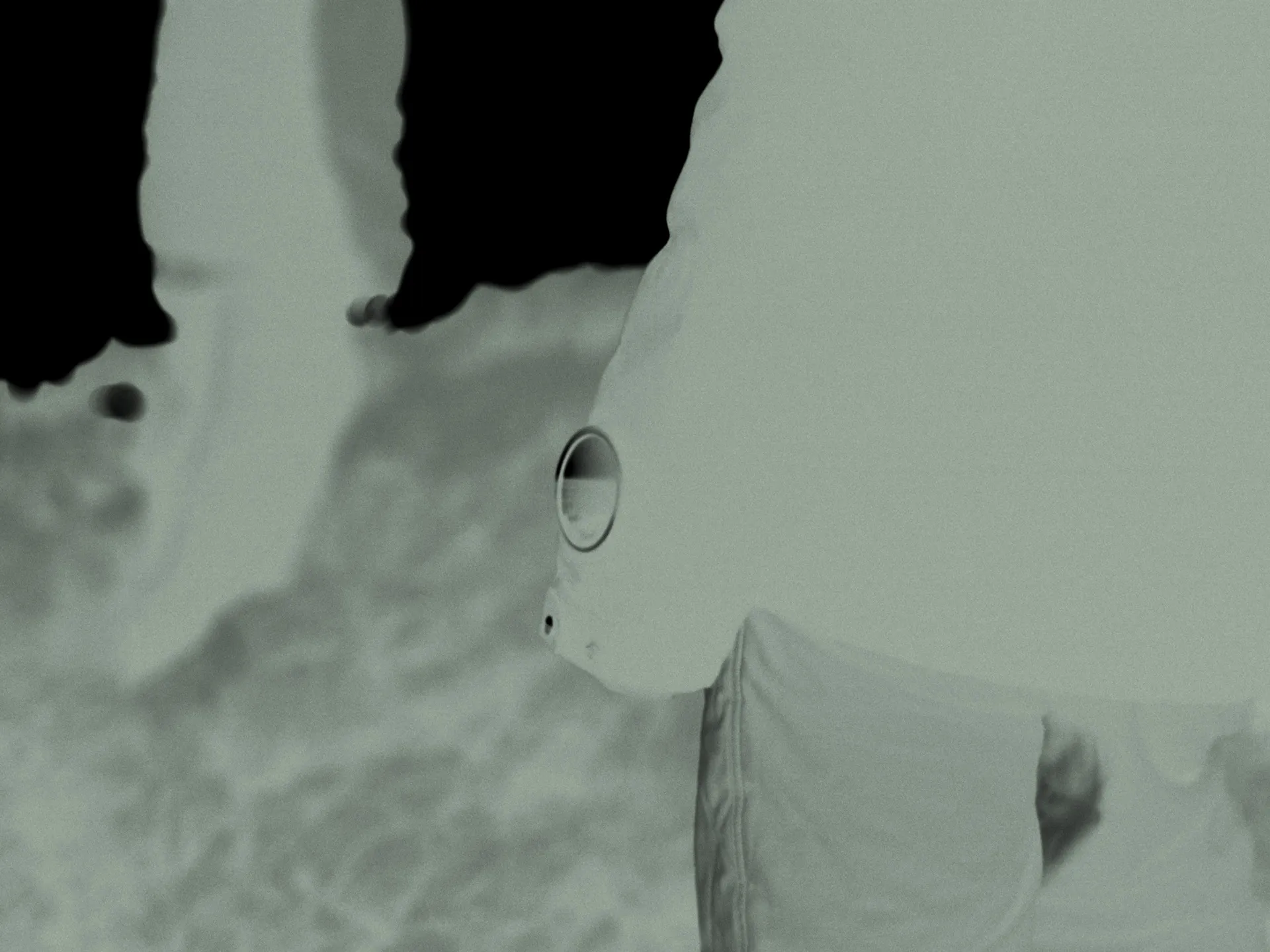 Person wearing a dark jacket and trousers standing on cobblestone pavement.