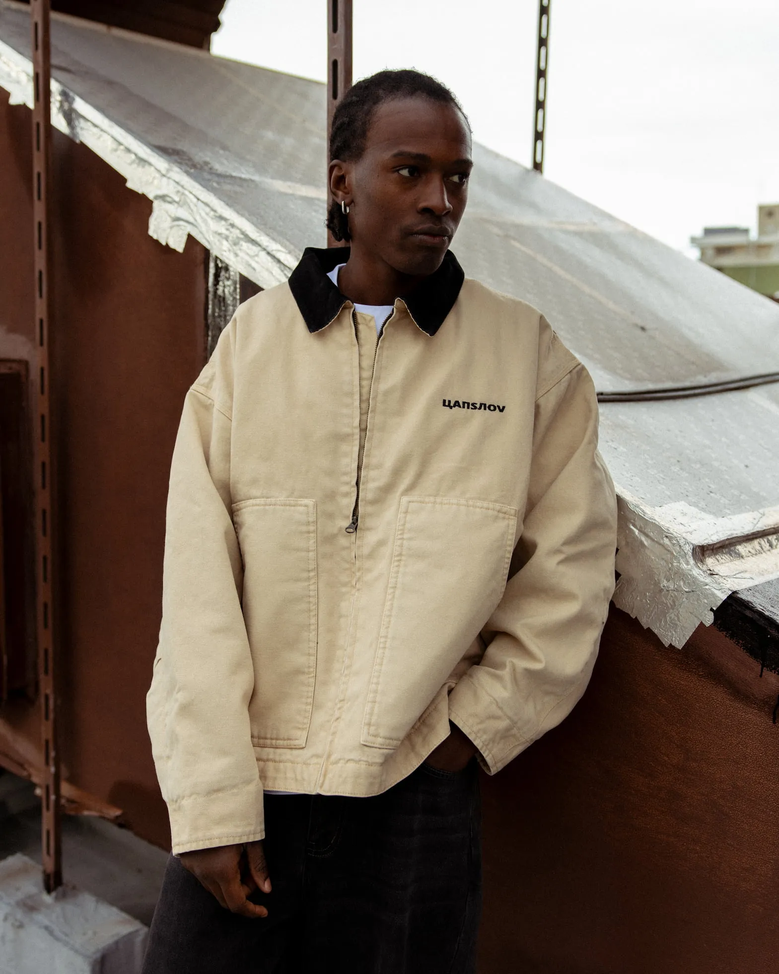 Man wearing a beige jacket on the roof top