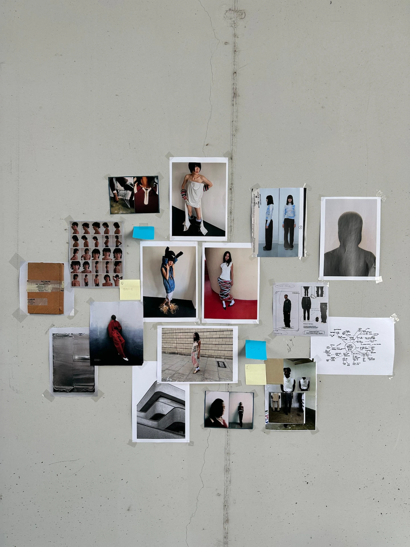 Gray wall with an arranged collage of fashion and architectural photographs, sketches, and sticky notes.
