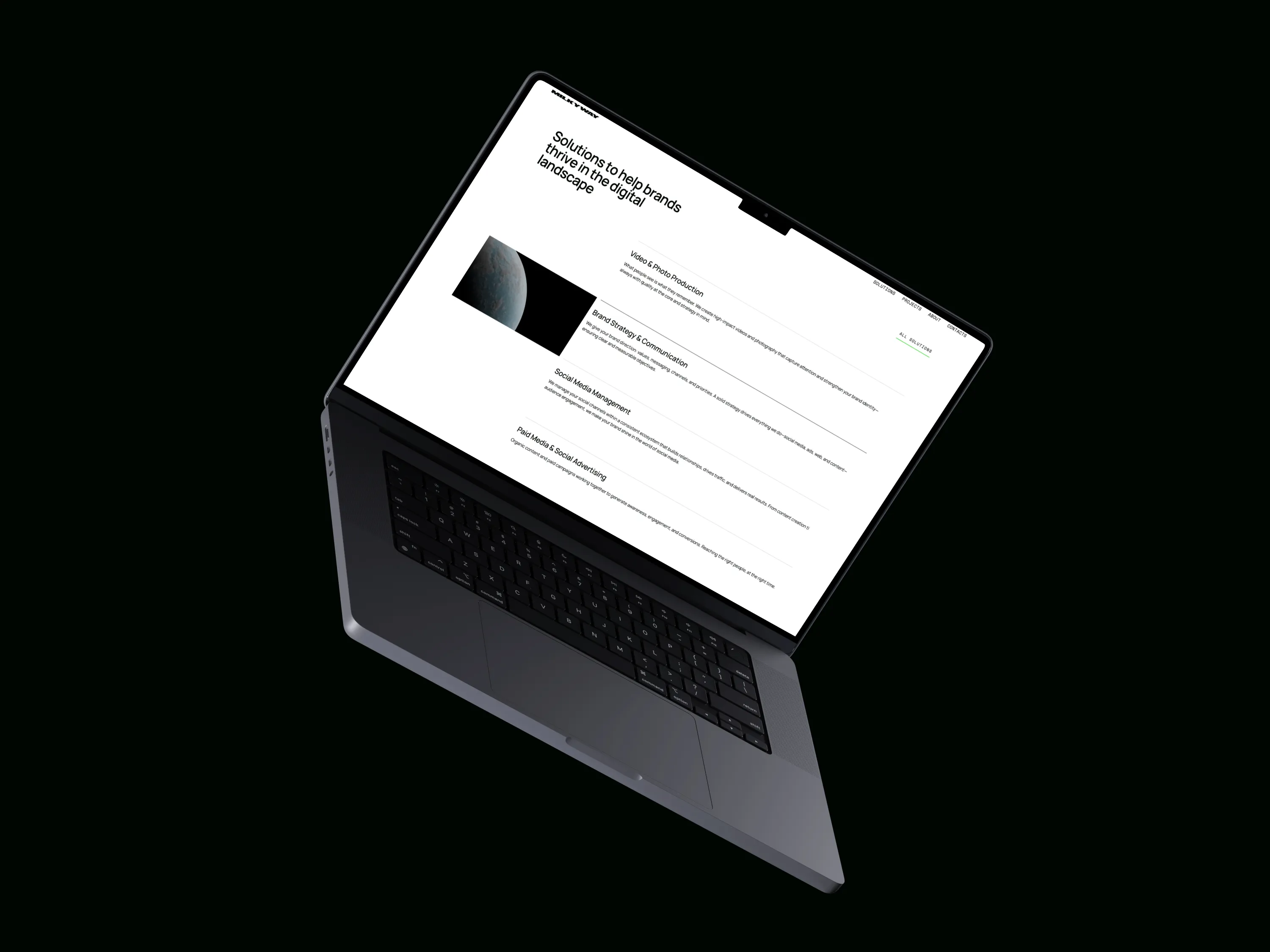 Laptop showing a webpage titled 'Solutions to help brands thrive in the digital landscape' with sections on video production, brand strategy, social media management, and advertising.