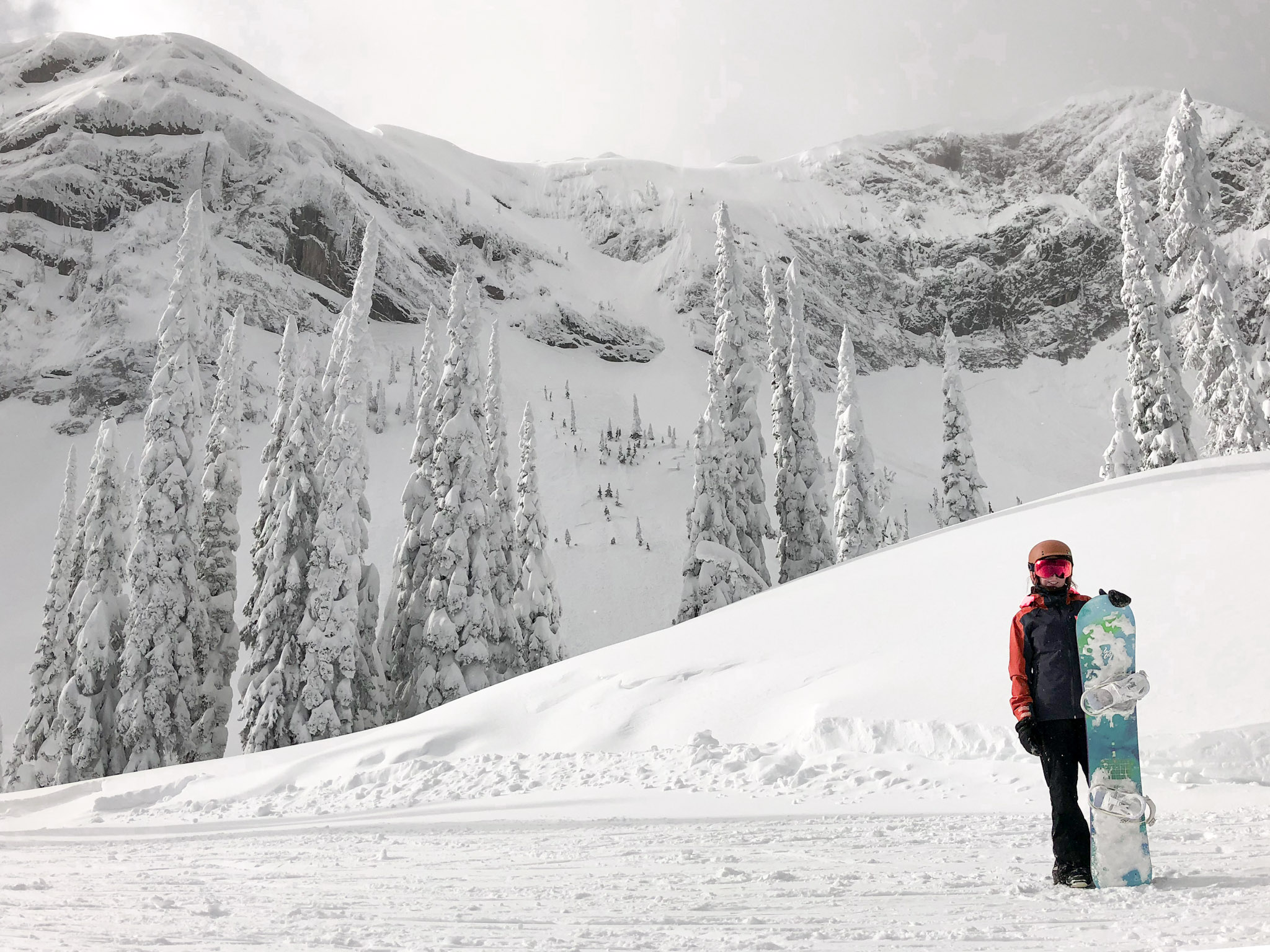 snowboarder, soph, stands in front of the headwall at fernie alpine resort in british columbia, canadaa