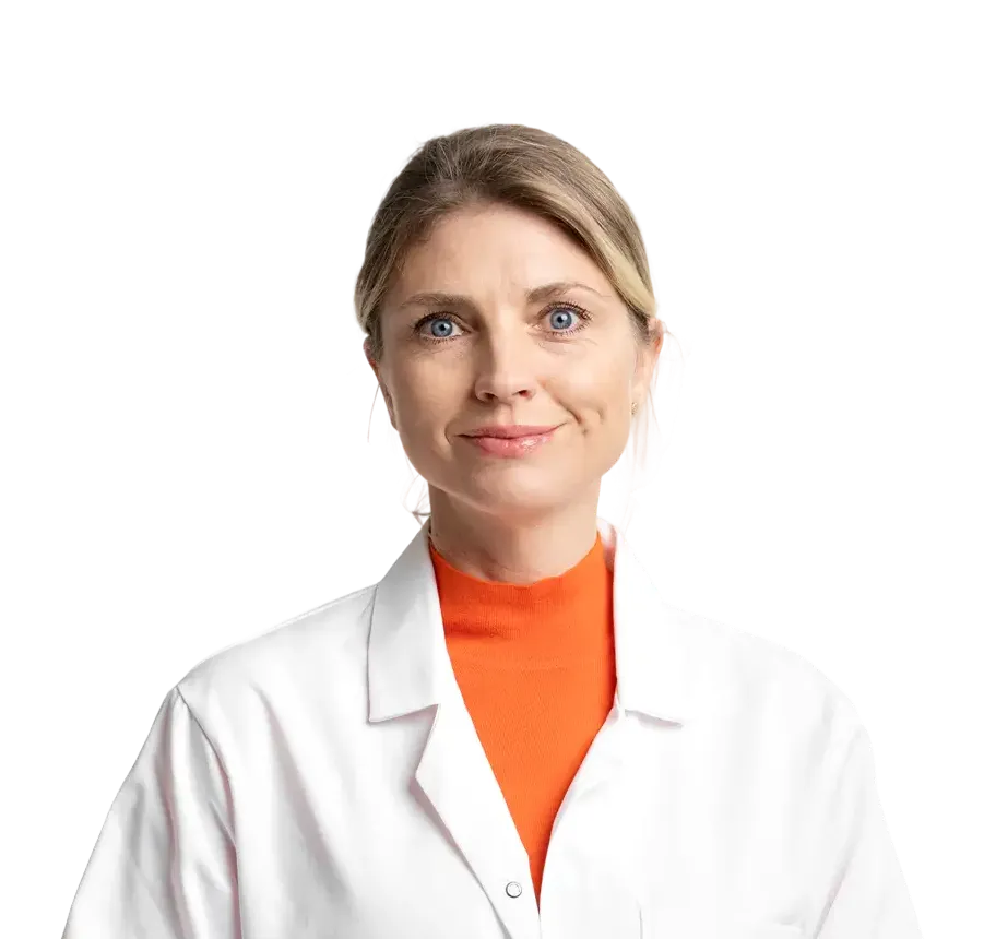 Smiling woman with blue eyes wearing an orange top and white lab coat on a transparent background.