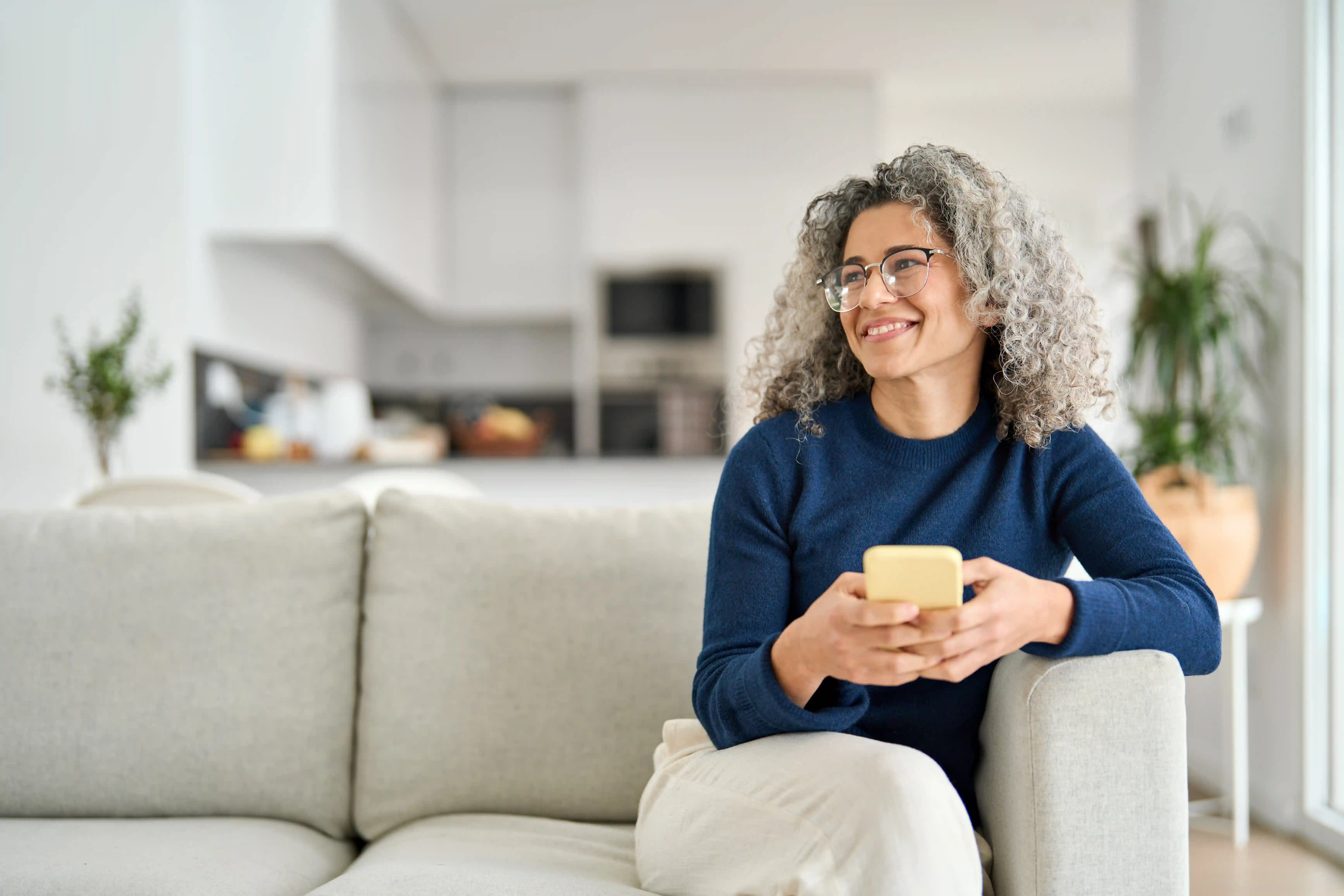 Woman sitting on a sofa with the phone in her hands