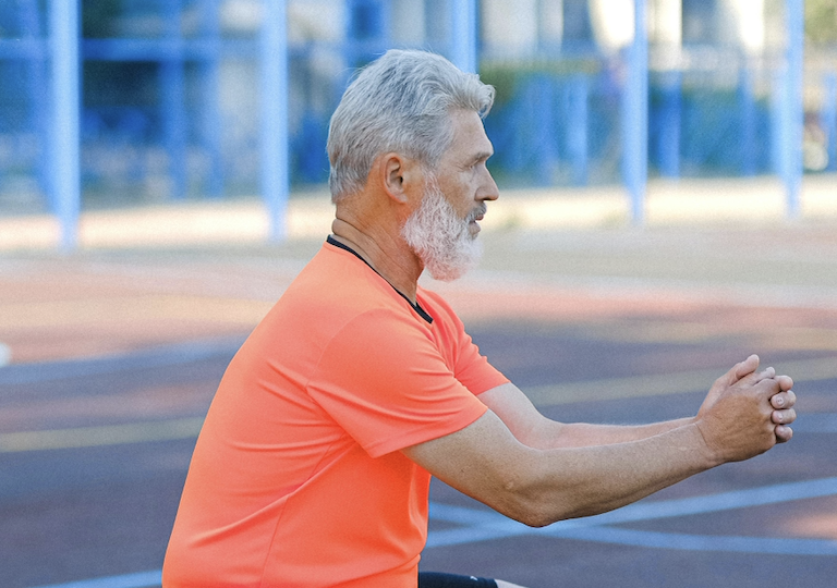 A middle-aged man doing squats and exercising.