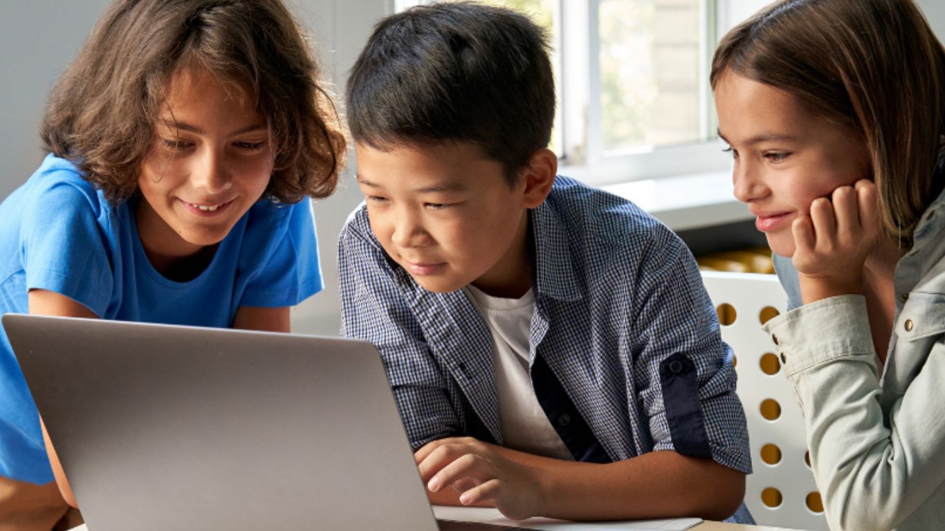 A group of kids creating with a laptop