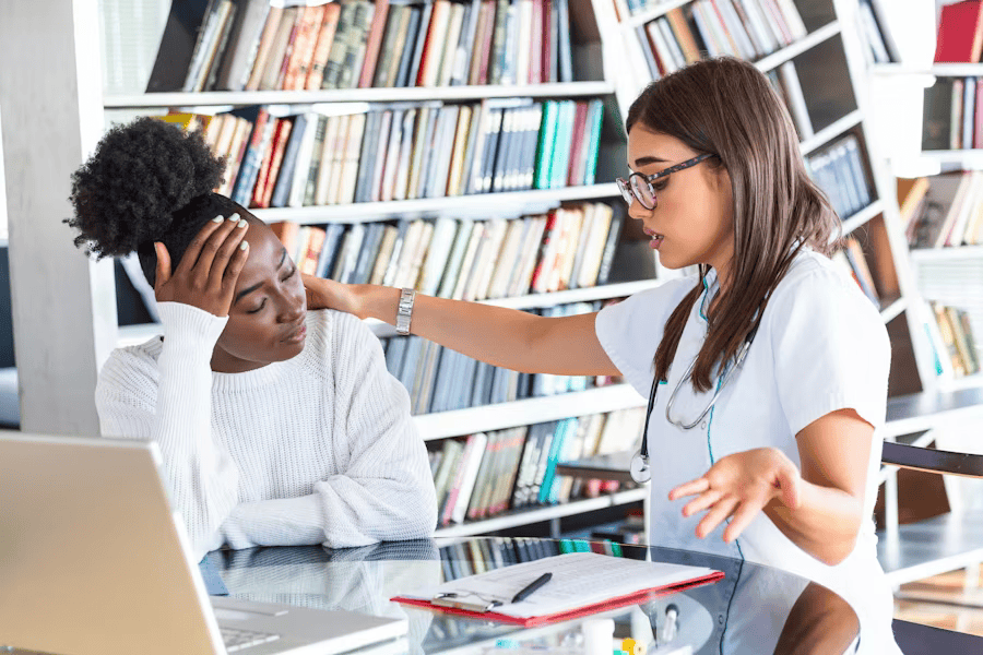 Eine Frau wird von einer Ärztin wegen ihrer Spannungskopfschmerzen behandelt.