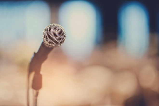 A pixelated background with focus on a microphone.