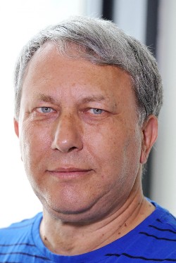 Photo close-up of Peter who is smiling at the camera. He has light blue eyes.