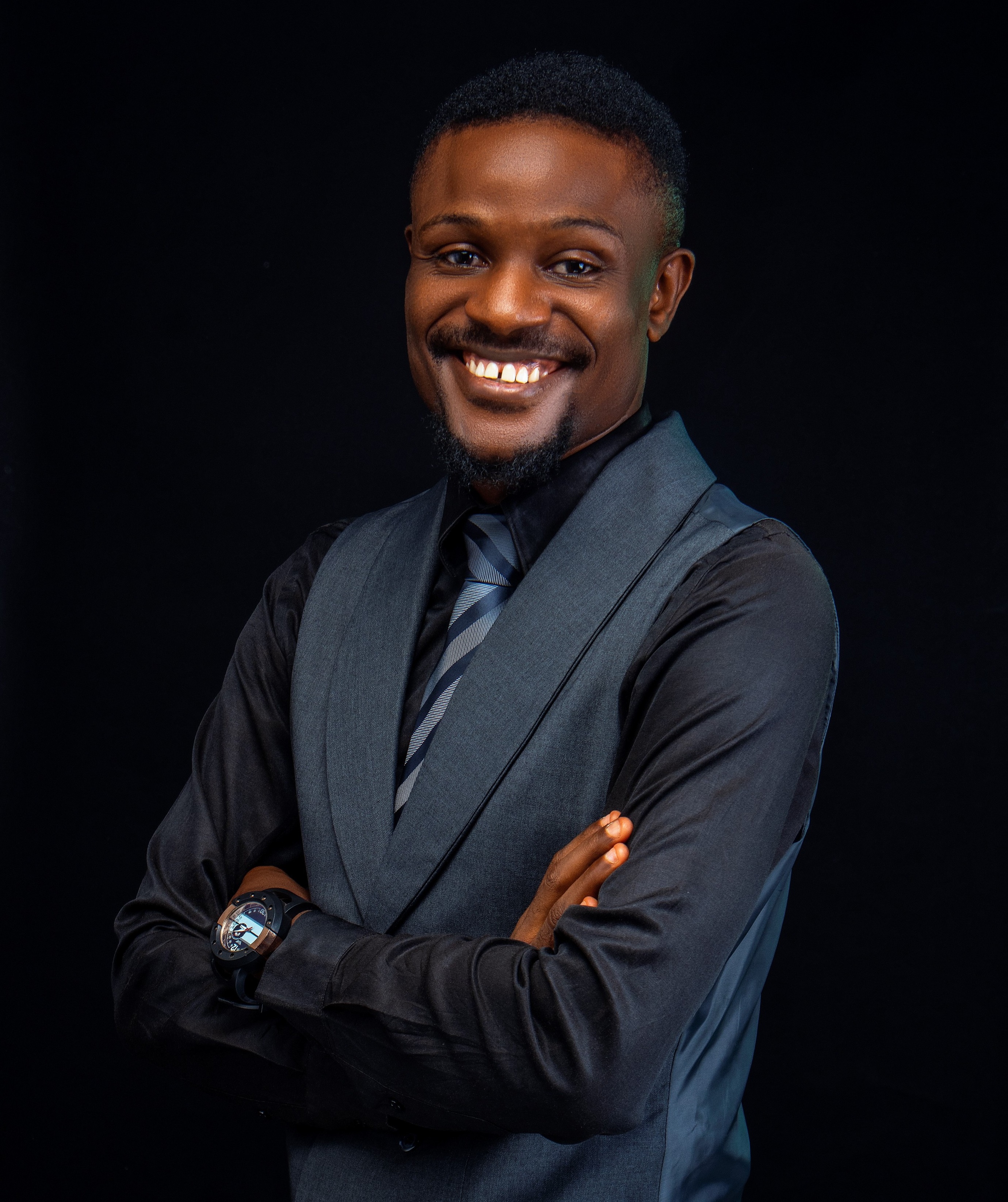 Photo of Kelvin Opiepie a man wearing a navy suite with navy shirt and navy tie