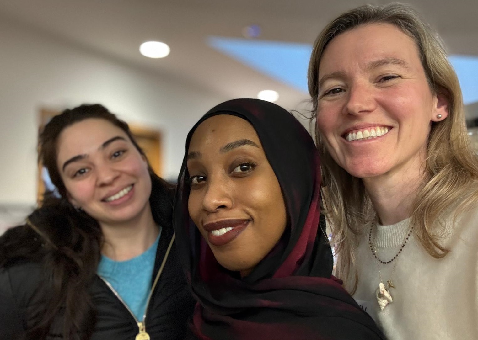 Photo of Hania a woman wearing with dark brown hair wearing a black zip coat and blue jumper, Asma a woman wearing a black and red hijab and Vita a woman with blonde hair wearing a cream jumper