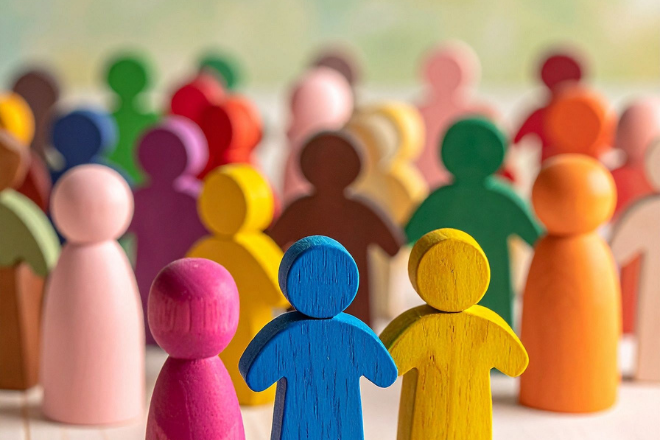 A group of brightly coloured wooden peg people arranged in rows.